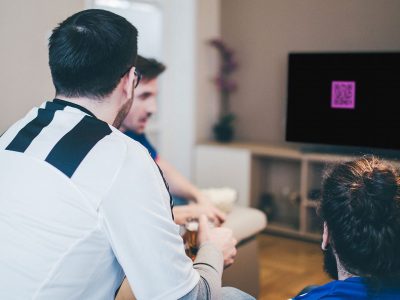 Guys watching TV with Coinbase ad