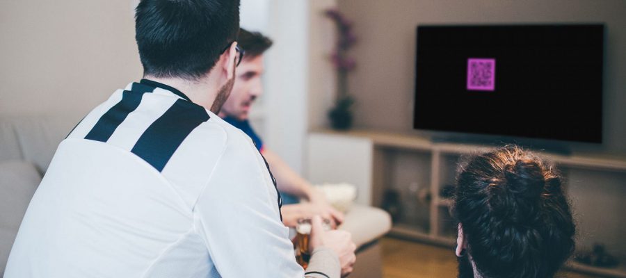 Guys watching TV with Coinbase ad